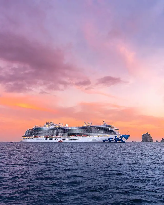 Majestic Princess pictured in ocean water hued in pinkish sky