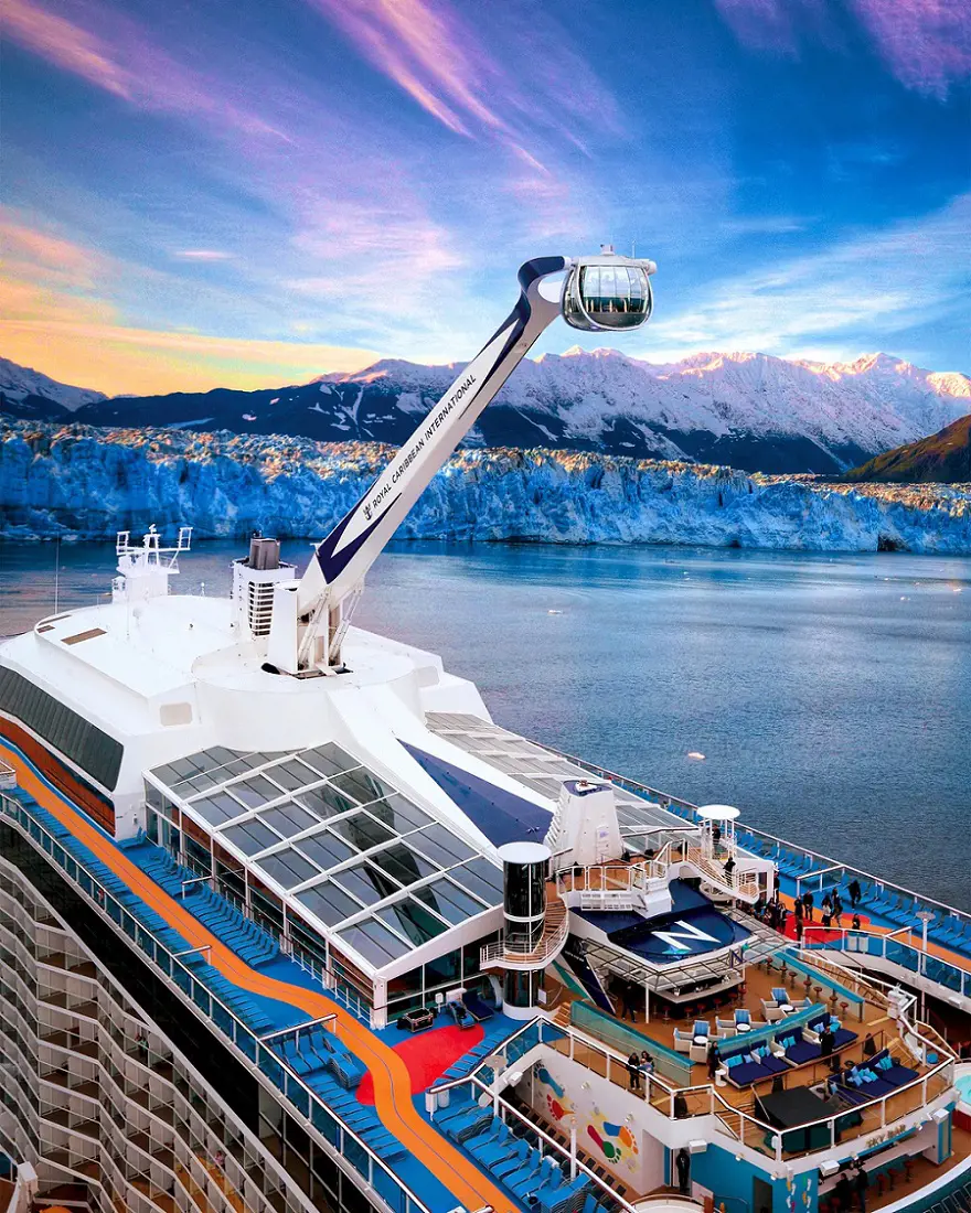 Quantum of the Seas pictured with snow capped mountains and seawater.